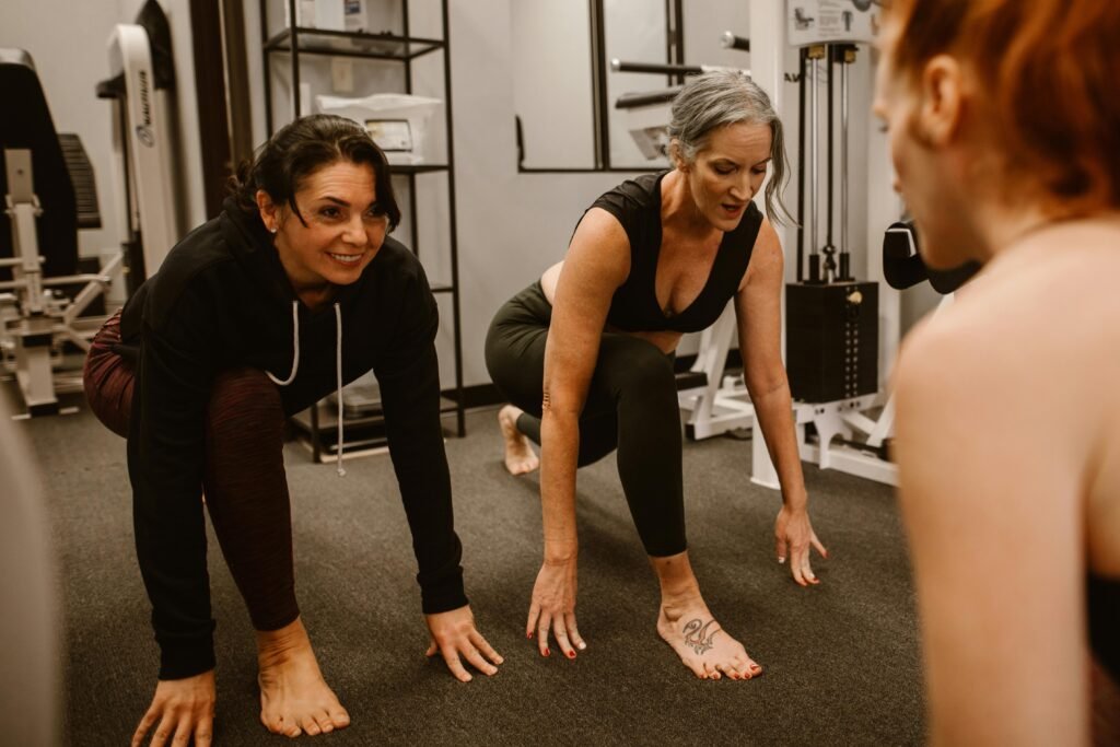pexels-photo-6539870-6539870 Three women engaged in a workout session in a gym, focusing on strength and balance.