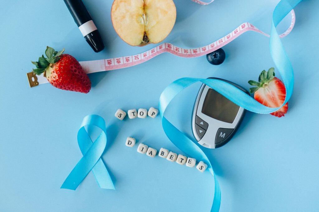 pexels-photo-6942085-6942085 Creative diabetes awareness with fruits, glucometer, and ribbon on blue background.