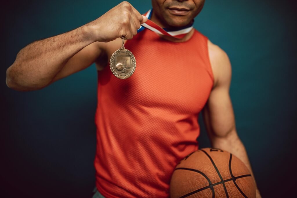 pexels-photo-7005758-7005758 Man holding a medal and basketball, showcasing achievement in sports.