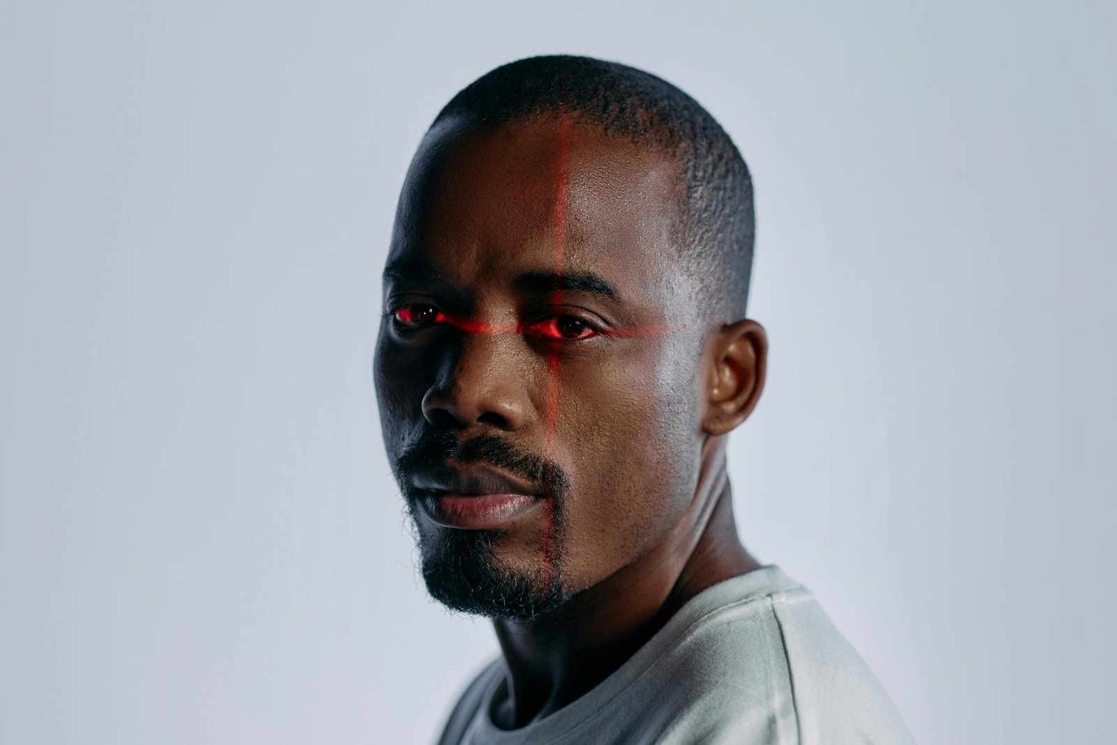 Close-up of a man with a futuristic laser scanning effect over his eyes, suggesting technology and identity themes.