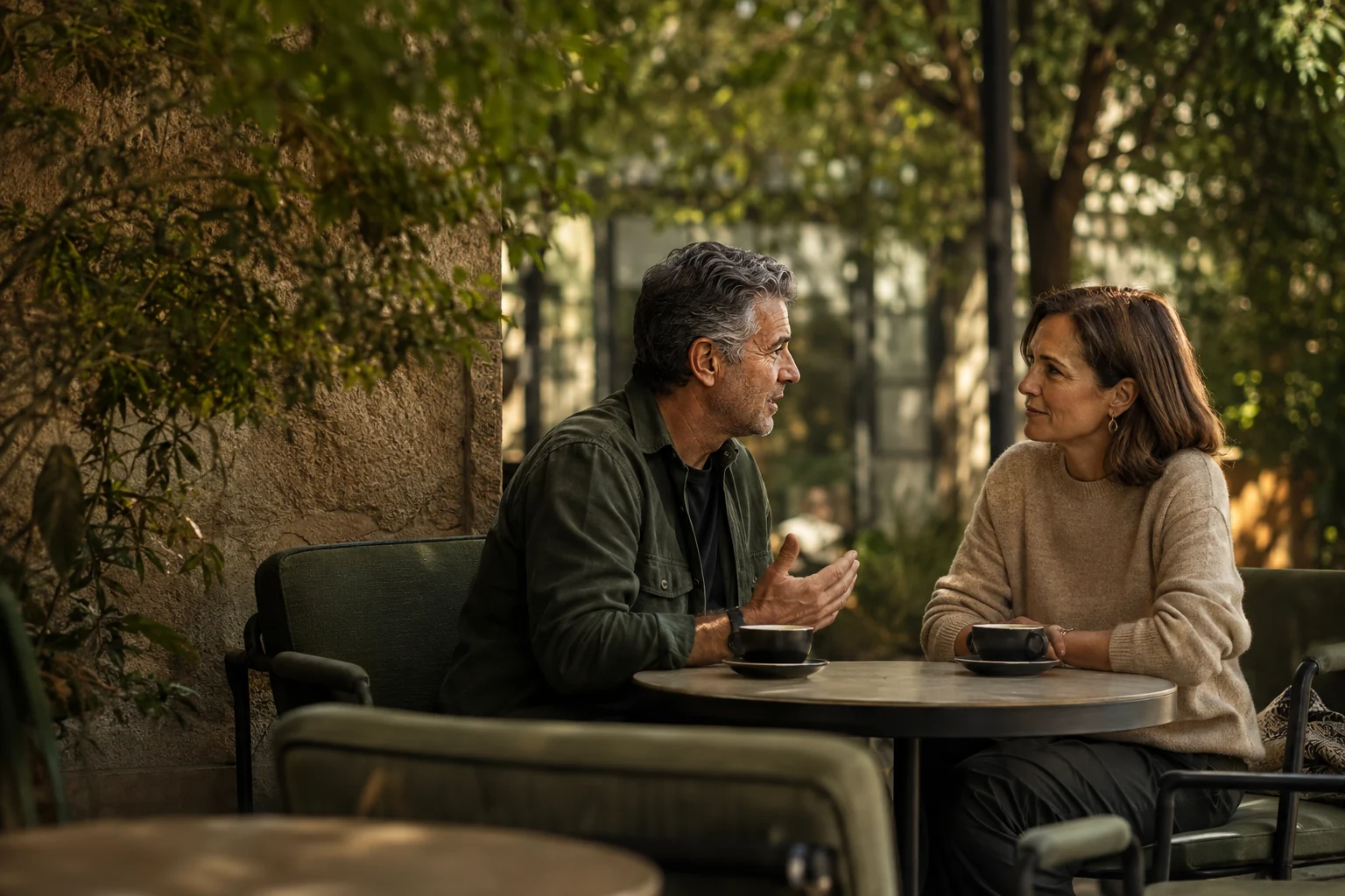 A mature couple having a relaxed conversation at an outdoor café table