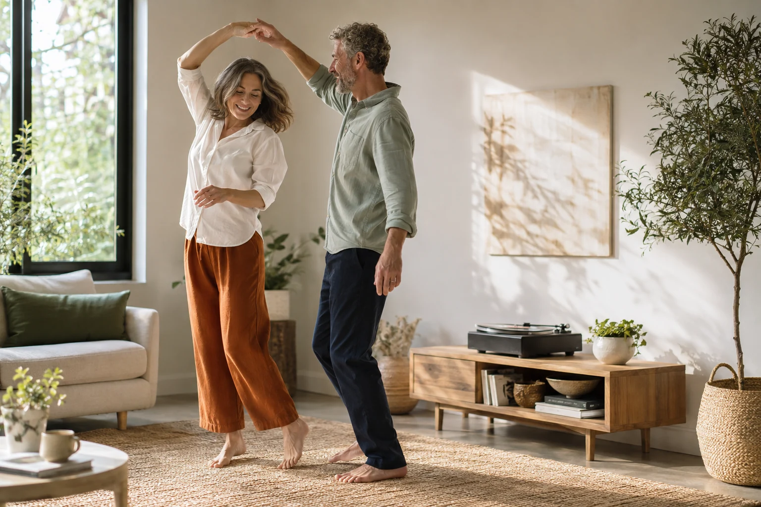 A mature adult couple dancing together in a sunlit living room