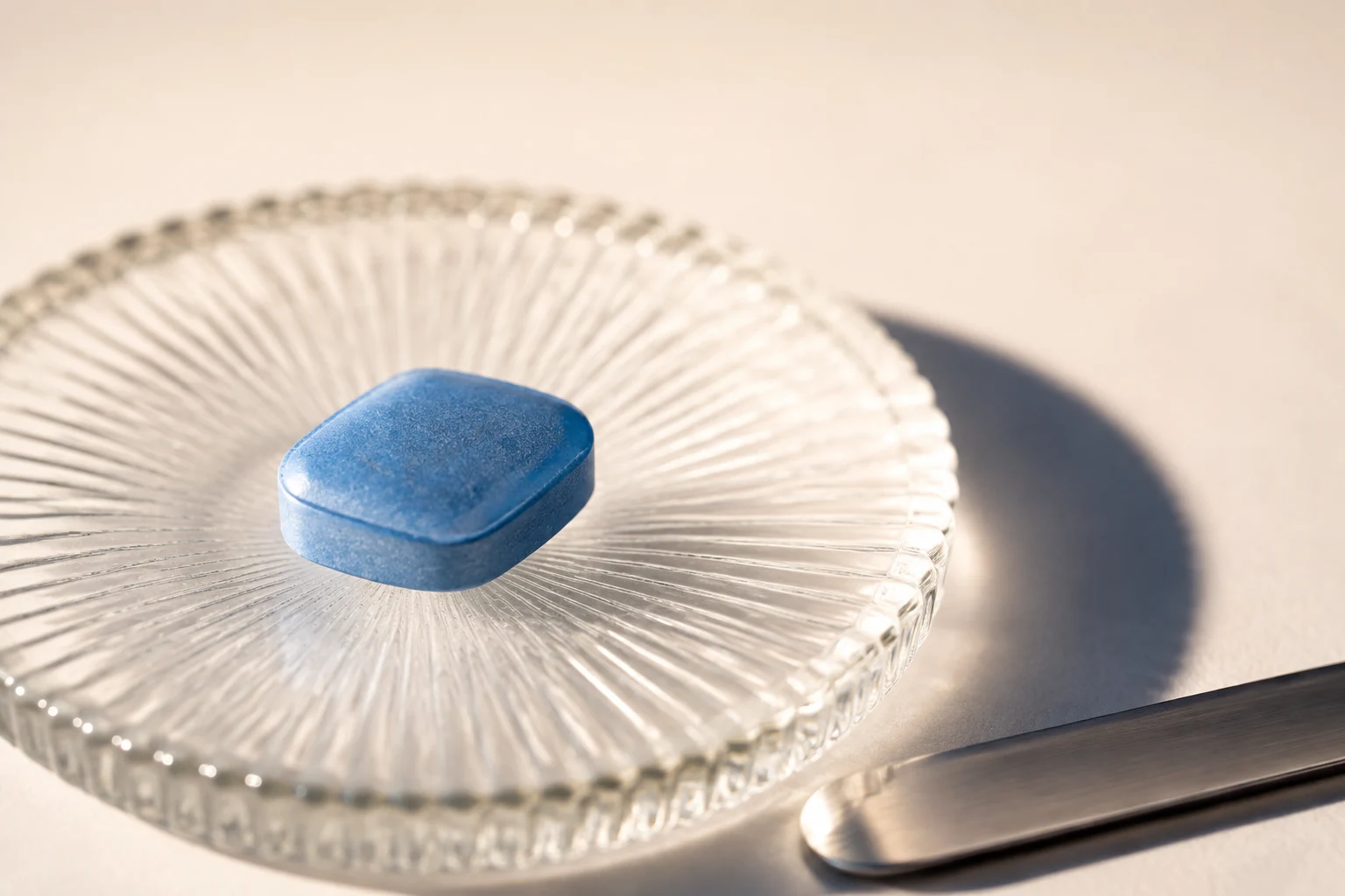 Blue diamond-shaped tablet on ribbed glass in close-up