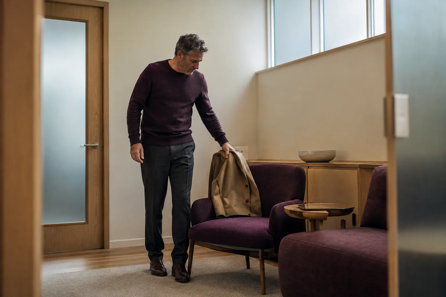 Man putting his coat on a chair before a private appointment