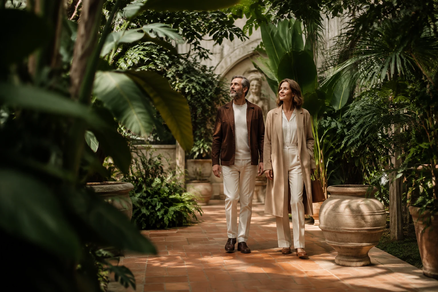 Mature couple walking through a lush botanical garden